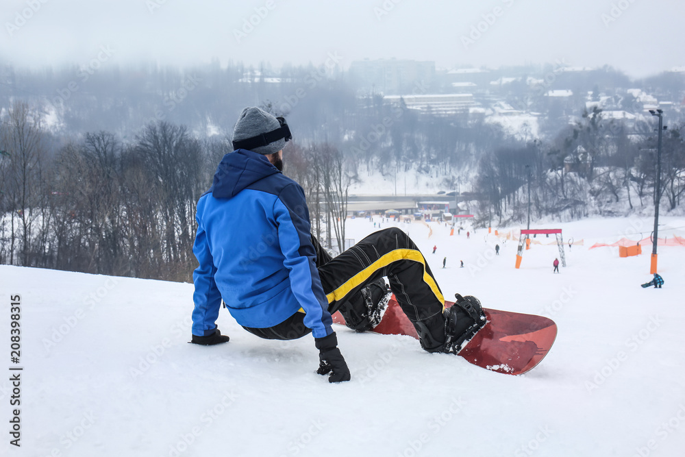 冬季度假区斜坡上的男单板滑雪运动员