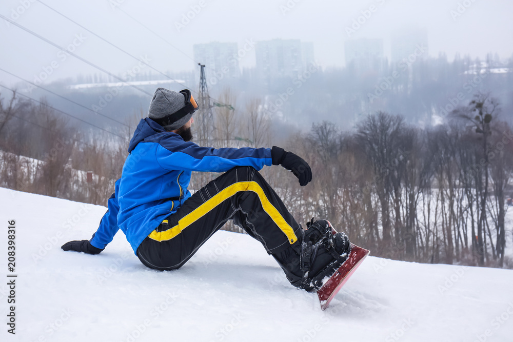 冬季度假区斜坡上的男单板滑雪运动员