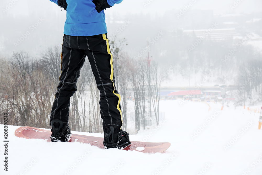 Male snowboarder on slope at winter resort