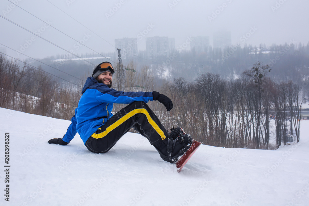 Male snowboarder on slope at winter resort