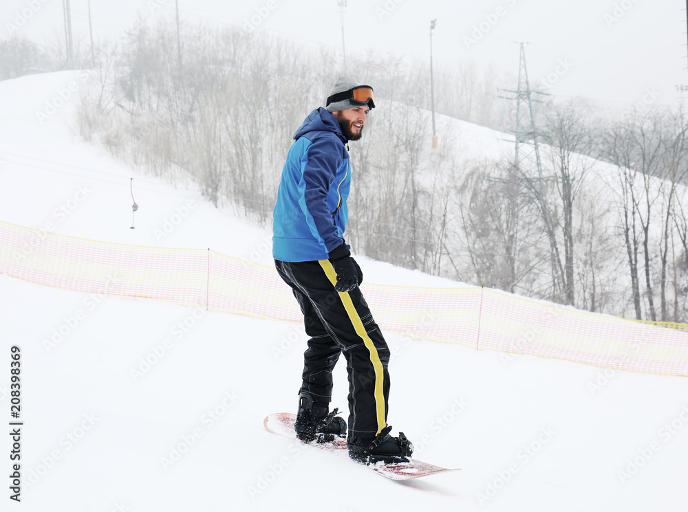 冬季度假胜地斜坡上的男子单板滑雪运动员