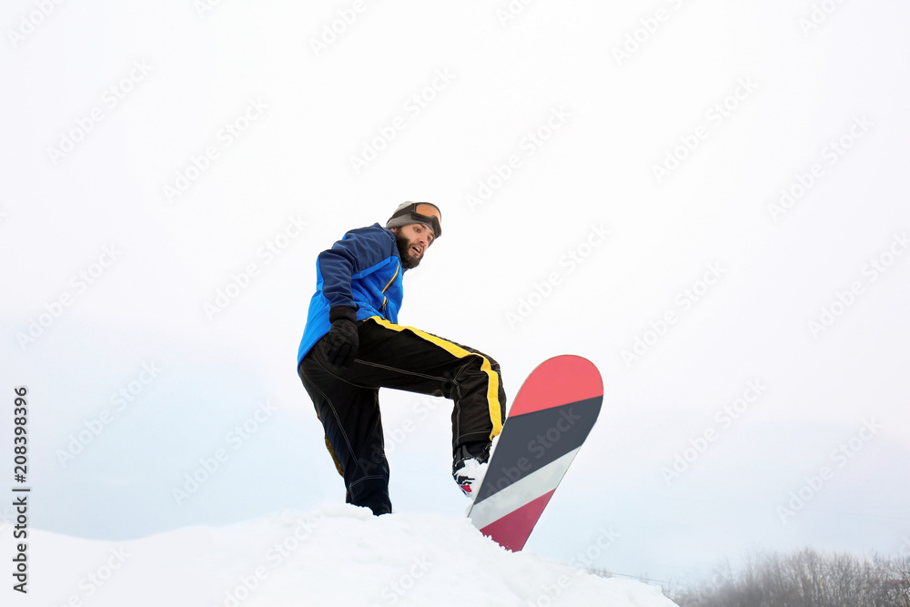 Male snowboarder on slope at winter resort