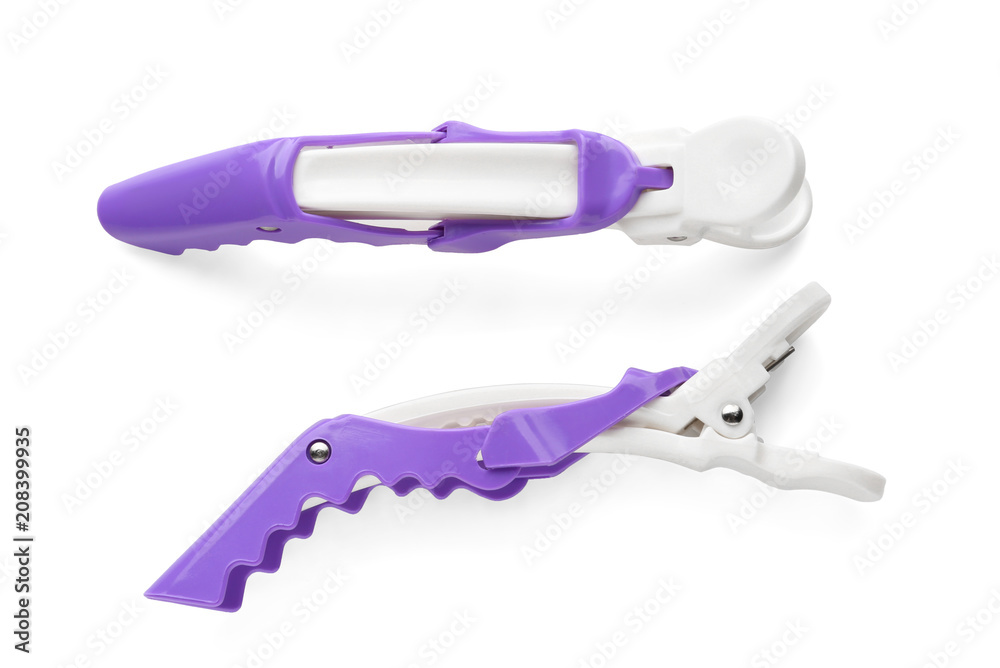 Hair clips on white background, top view. Professional hairdressers equipment