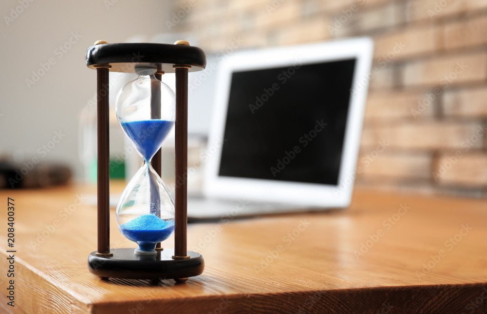 Hourglass on table in office. Time management concept