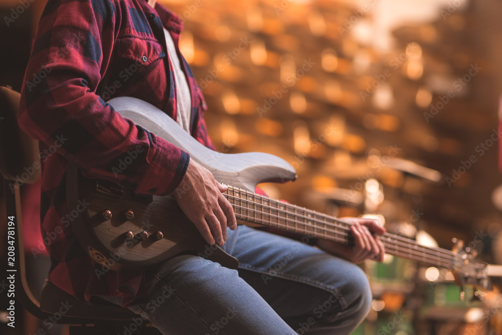 Young musician playing bass guitar