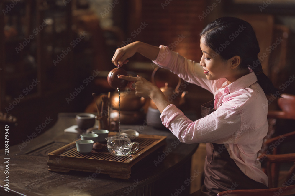 年轻女子在房间里倒茶