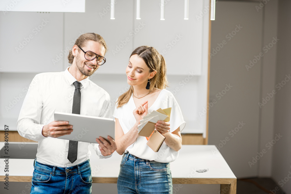 一对年轻夫妇设计了一个新的室内设计，里面有数字平板电脑和彩色样本