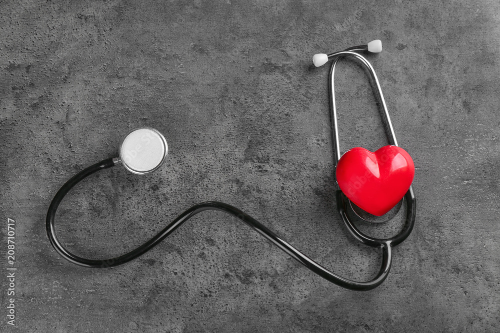 Stethoscope with small heart on dark grey background