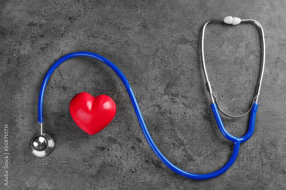 Stethoscope with small heart on dark grey background