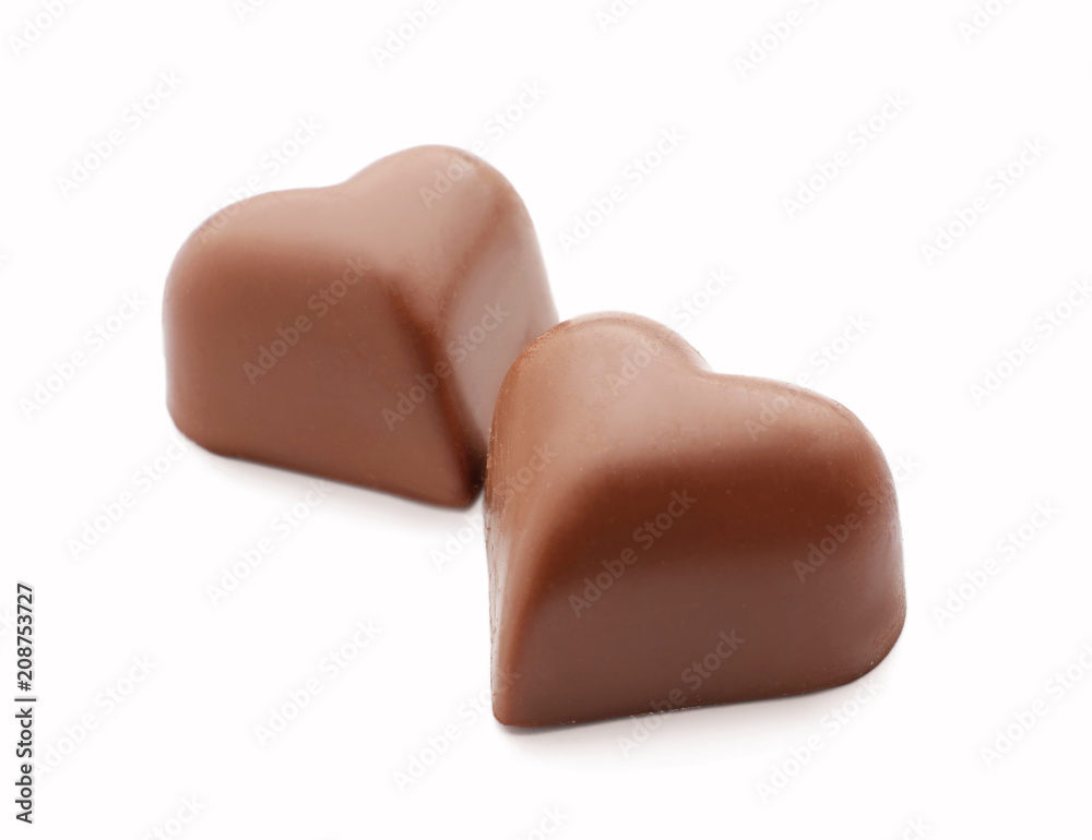 Tasty heart-shaped chocolate candies on white background