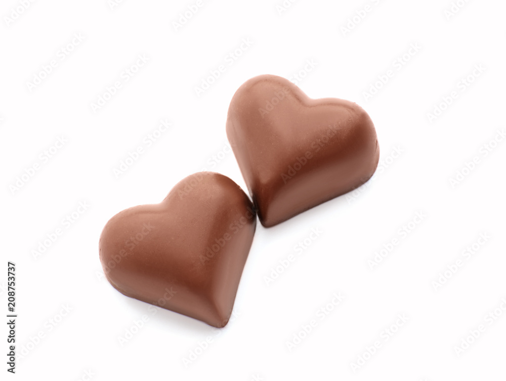 Tasty heart-shaped chocolate candies on white background