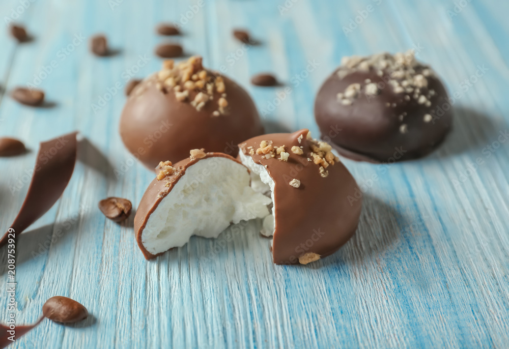 Tasty candies with milk chocolate on wooden table