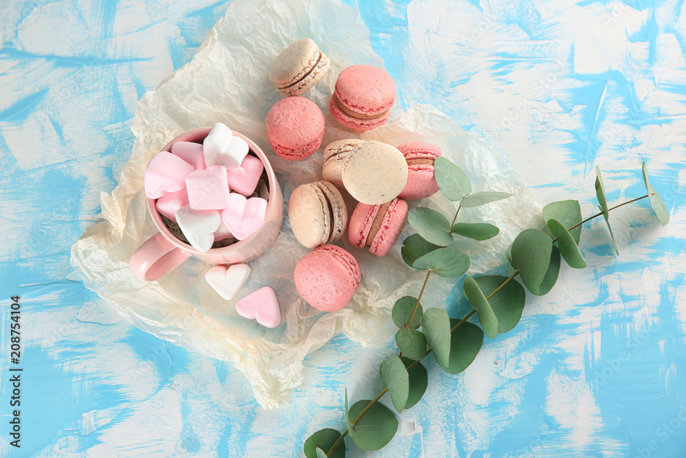 Flat lay composition with tasty macarons and marshmallows on table