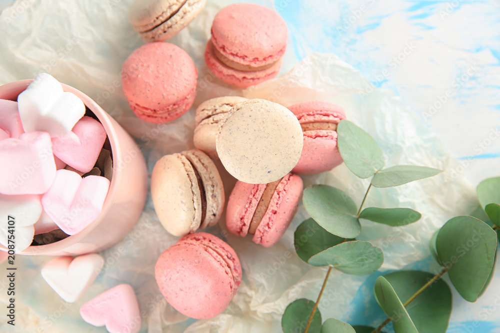 Flat lay composition with tasty macarons and marshmallows on table