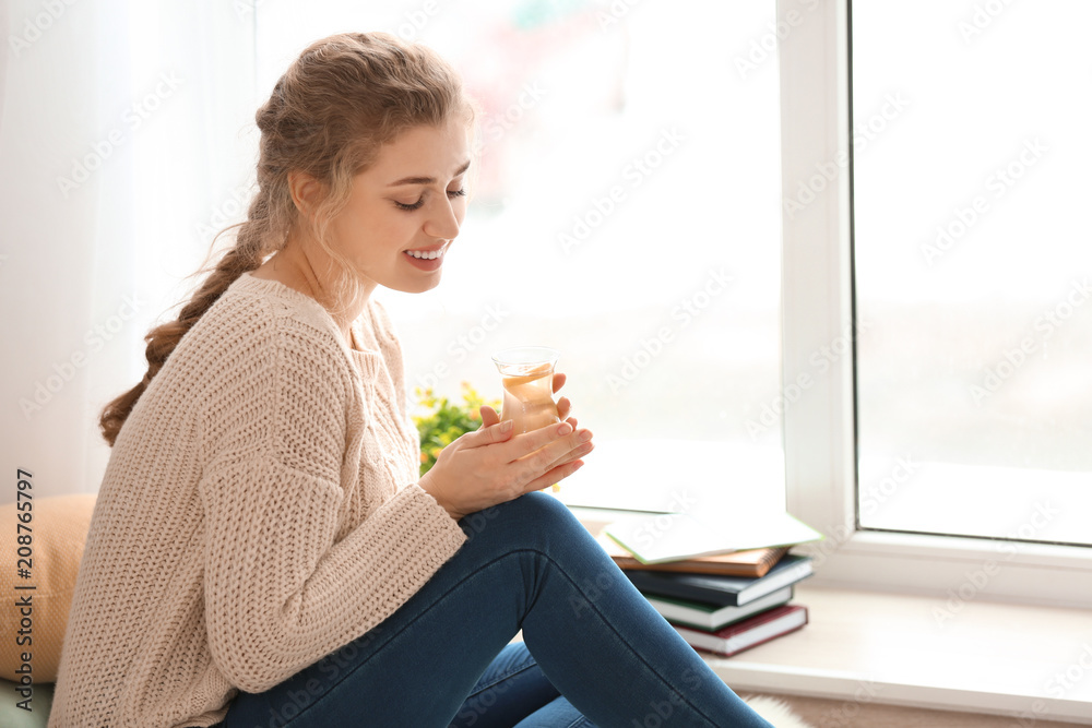 年轻女子在家里靠窗喝白茶