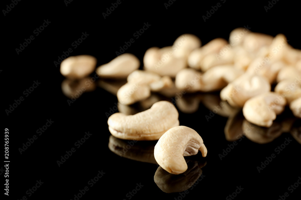 Tasty cashew nuts on black background