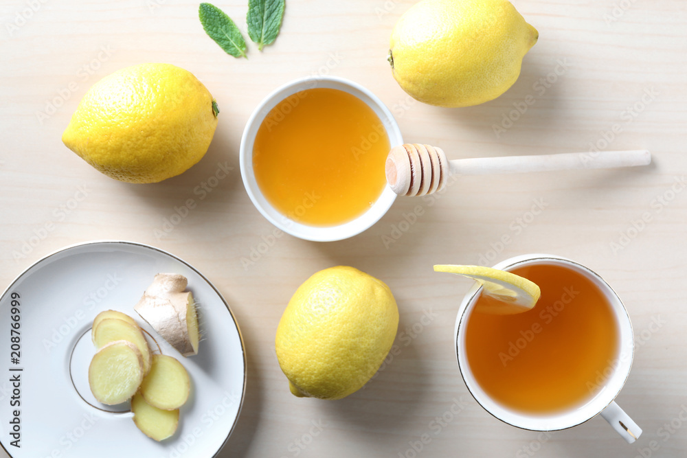 Cup of delicious tea with ginger, lemon and honey on table