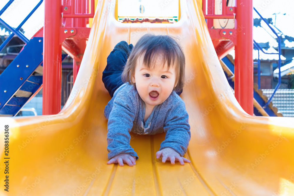 混血幼童在操场上玩滑梯