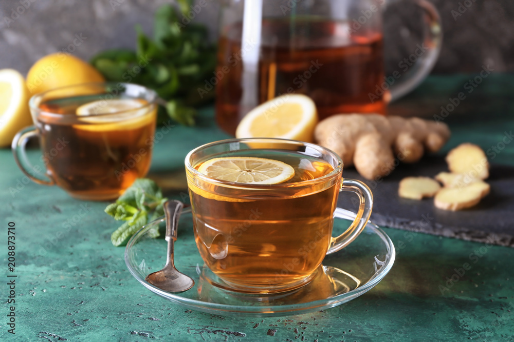 Cup of hot tea with ginger and lemon on table