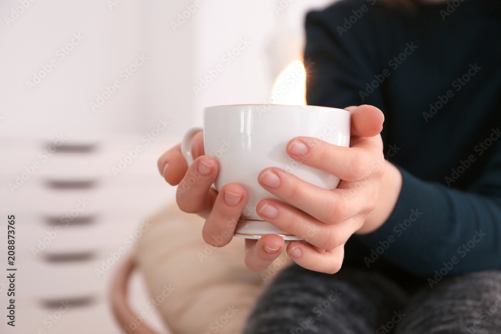 年轻女子在室内喝柠檬和生姜的绿茶，特写