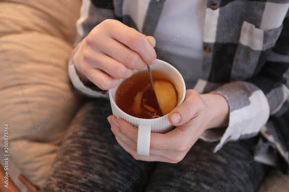 年轻女子在室内喝柠檬生姜绿茶，特写