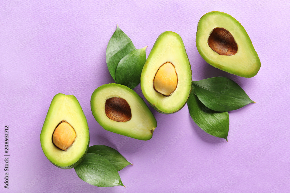 Halves of ripe avocados on light background