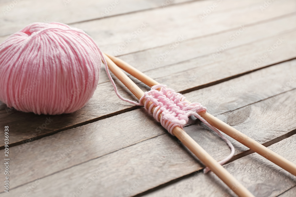 Knitting yarn with needles on wooden table