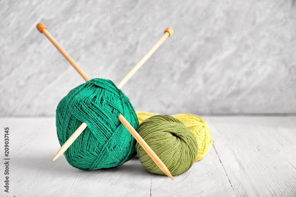 Knitting yarn with needles on wooden table