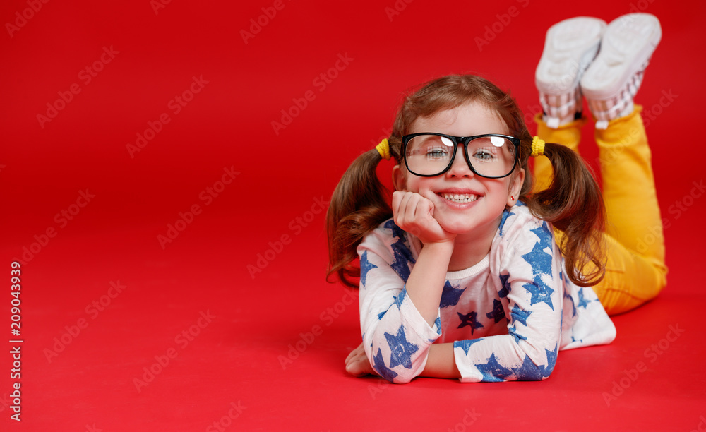 funny child girl in glasses on colored background