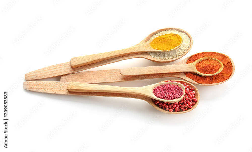 Wooden spoons with various spices on white background