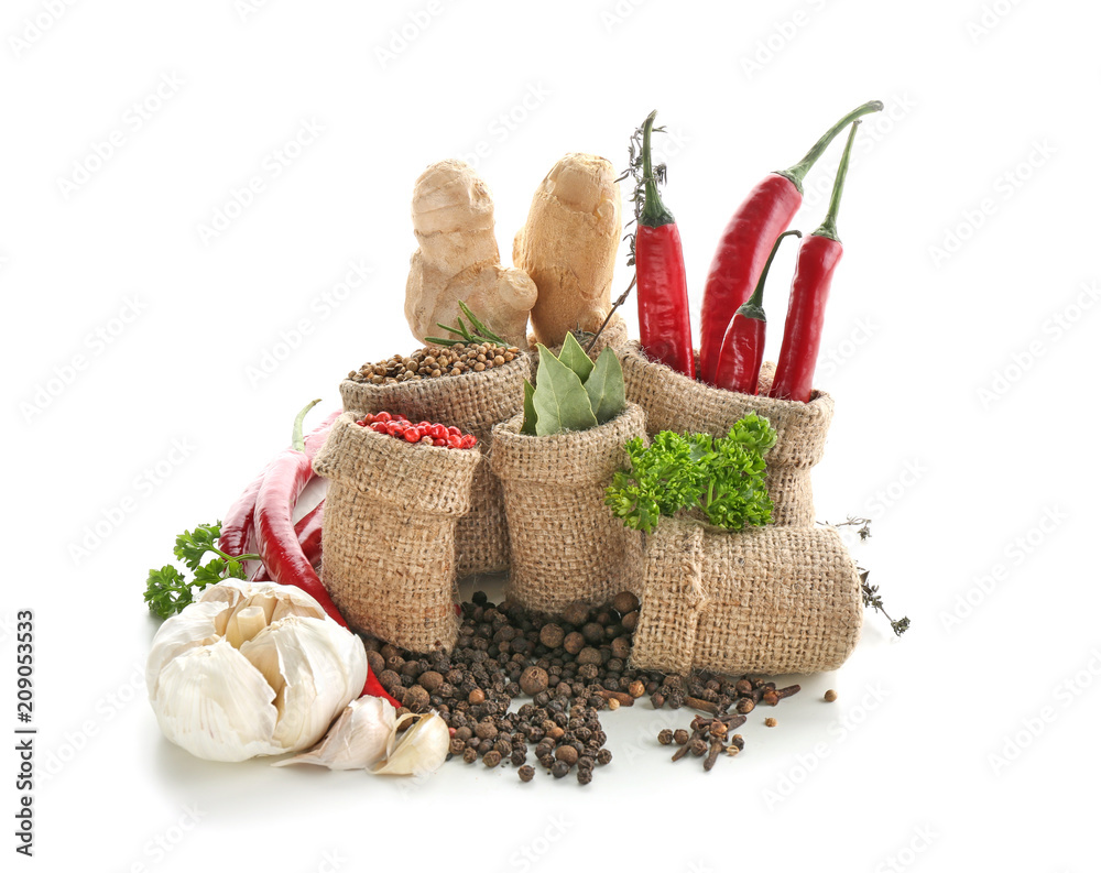 Sacking bags with various spices and vegetables on white background