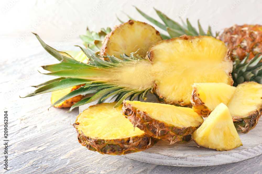 Stand with delicious pineapples on wooden background