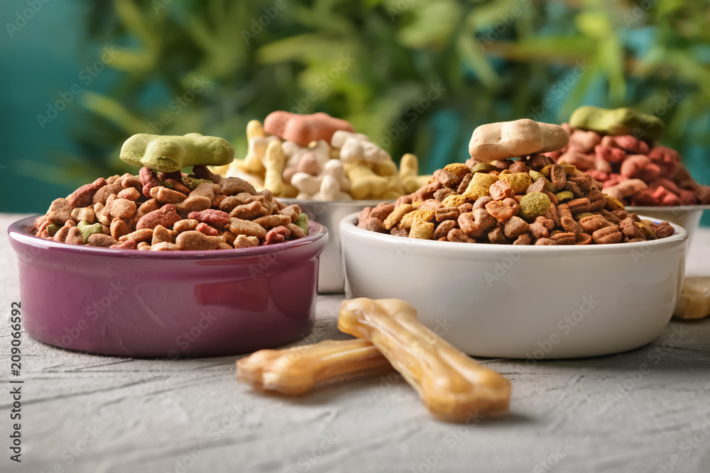 Bowls with pet food on table