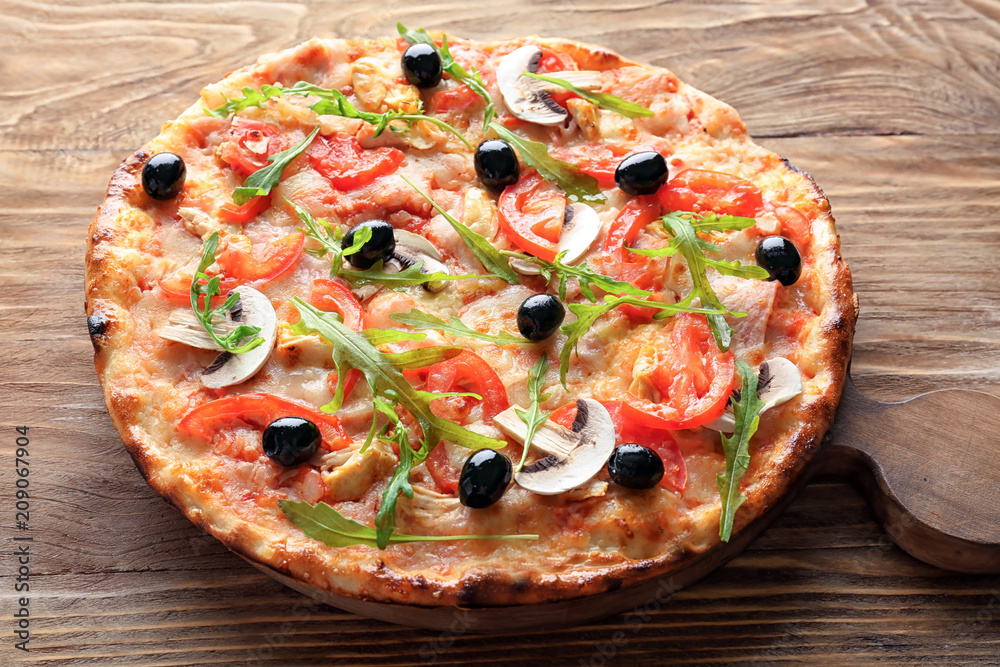 Board with tasty Italian pizza on wooden table