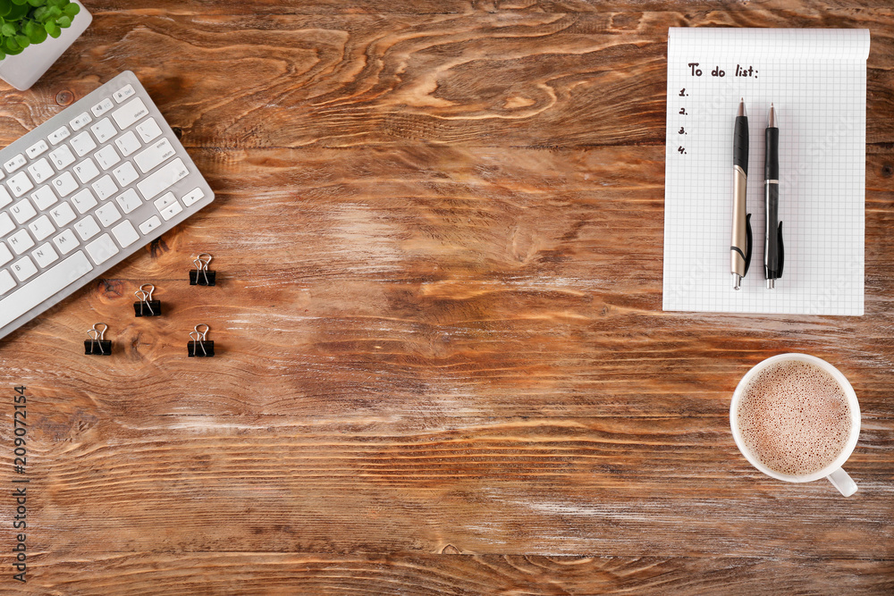 Empty to-do list with cup of coffee and computer keyboard on wooden background