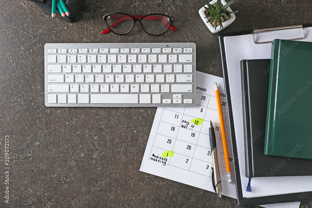 Calendar with to-do list, computer keyboard and notebooks on grey background