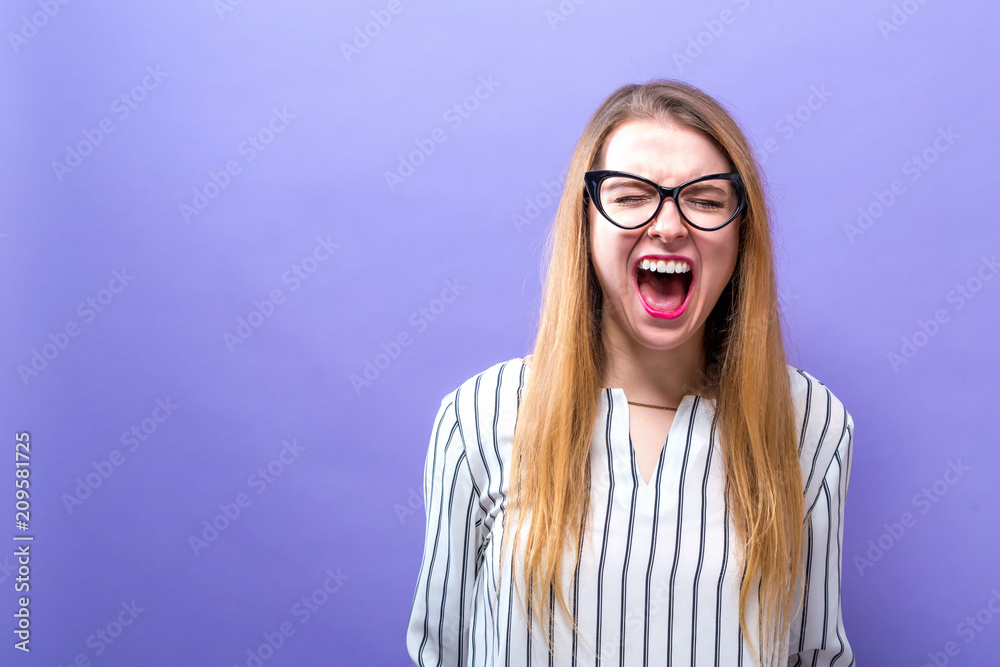 年轻女子在坚实的背景下尖叫