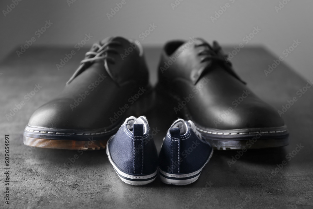 Big and small shoes on grey table. Fathers day