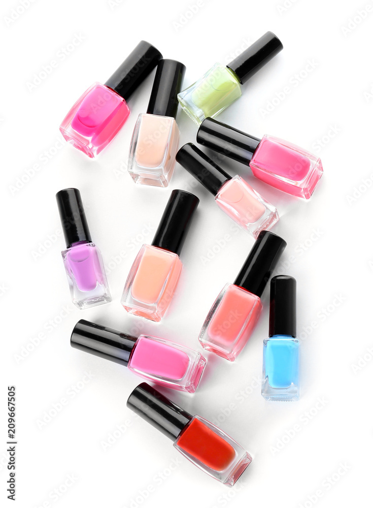 Bottles of colorful nail polishes on white background