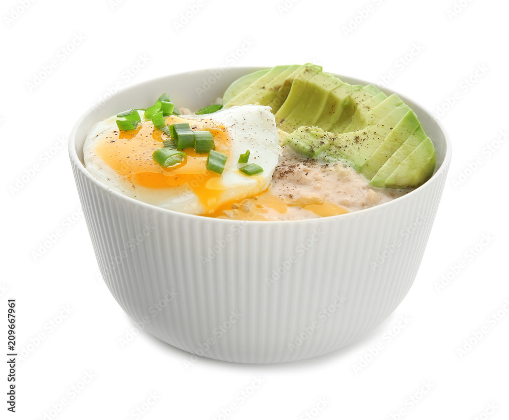 Bowl with tasty oatmeal, fried egg and sliced avocado on white background