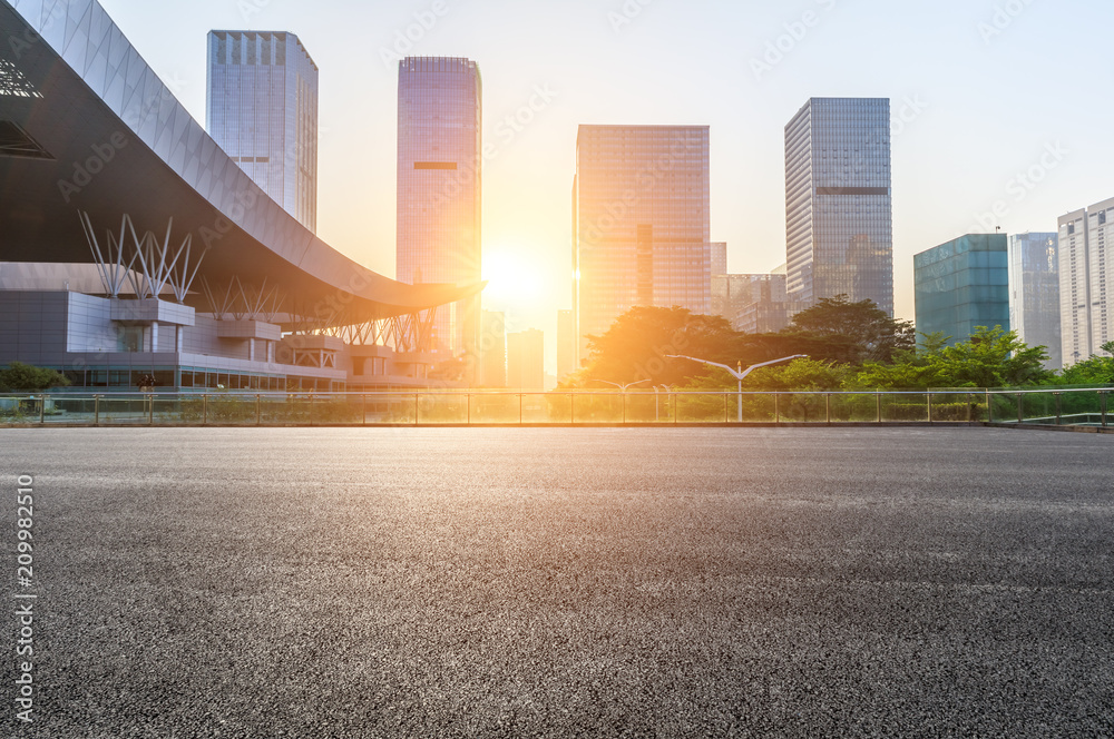 深圳日出时的空旷柏油路和现代城市商业建筑