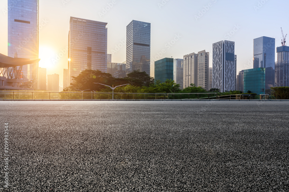 深圳日出时的空旷柏油路和现代城市商业建筑