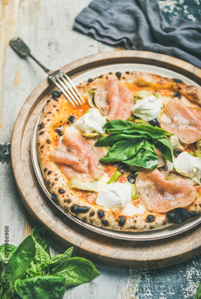 Italian lunch or dinner. Freshly baked pizza with artichokes, smoked turkey ham, olives, cream chees