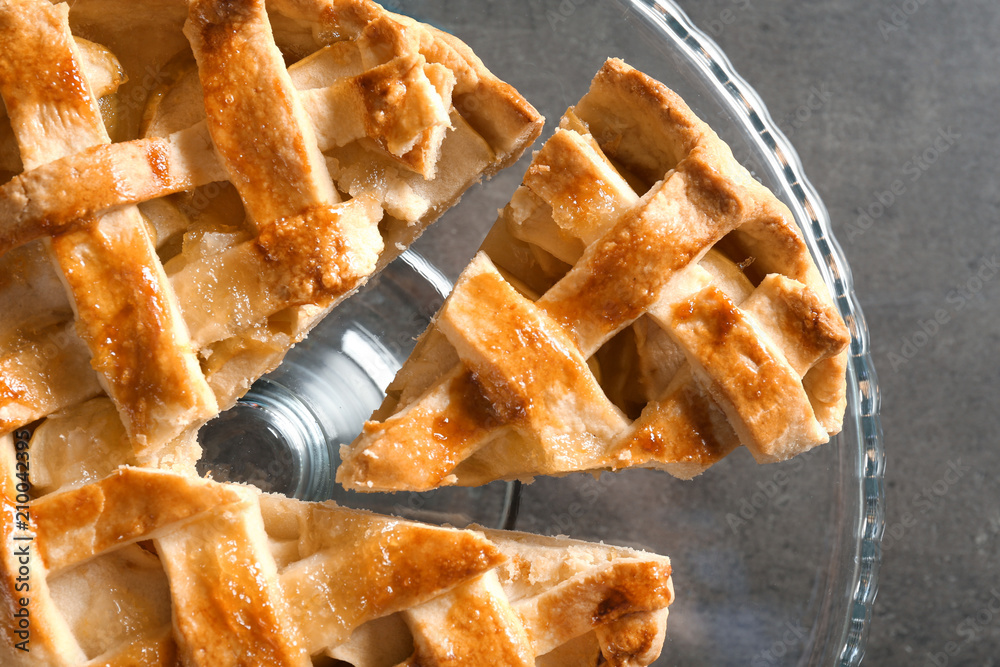 Glass stand with tasty homemade apple pie on grey background