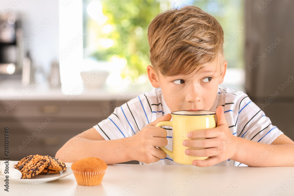 家里有一杯热可可饮料的可爱小男孩