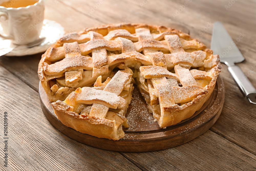 Board with delicious apple pie on wooden table