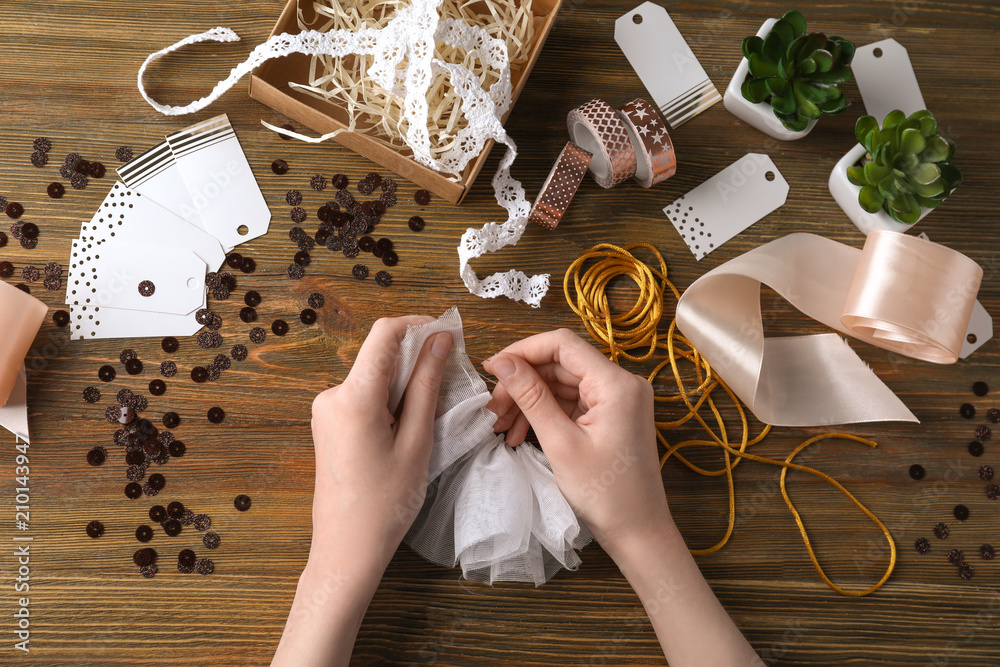 Woman preparing decorations for scrapbooking on wooden background