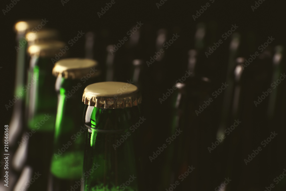 Glass bottles of cold beer on dark background, closeup