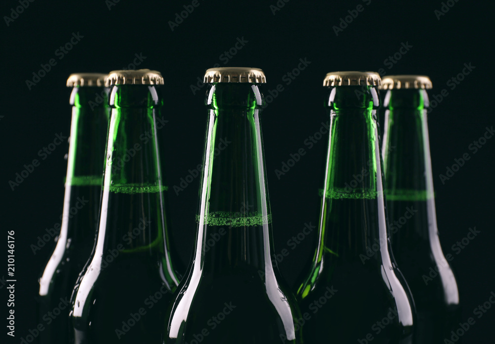 Glass bottles of cold beer on dark background