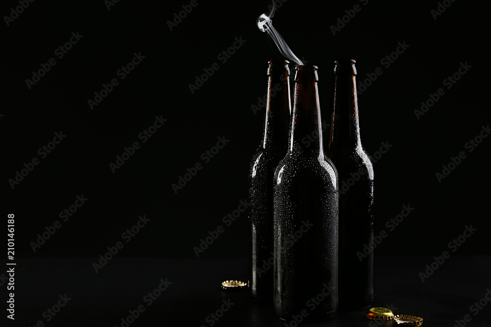 Glass bottles of cold beer on dark background